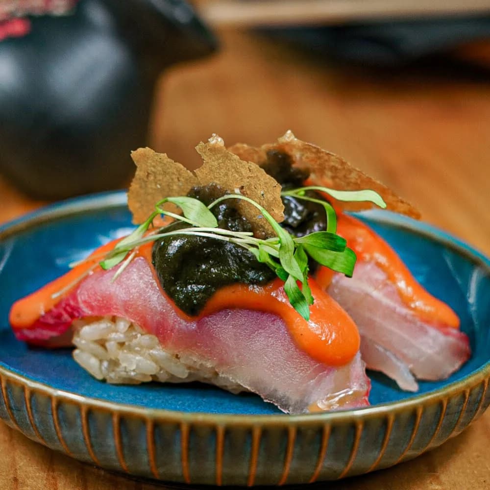 NIGIRI CON PESCA DEL DIA QUE COMBINA PLÁTANO, HUACATAY, LECHE DE TIGRE DE ROCOTO, PAPEL DE CAMOTE.