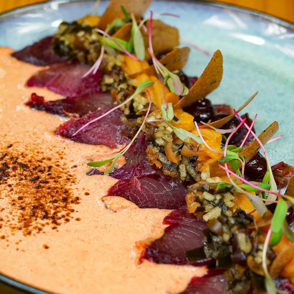 TIRADITO CON KATSUO CURADO, ACEVICHADA DE ROCOTO, EMULSIÓN DE CAMOTE, NIKU GEL, CHALAQUITA DE ALGAS POLVO DE NORI Y LECHE DE TIGRE.