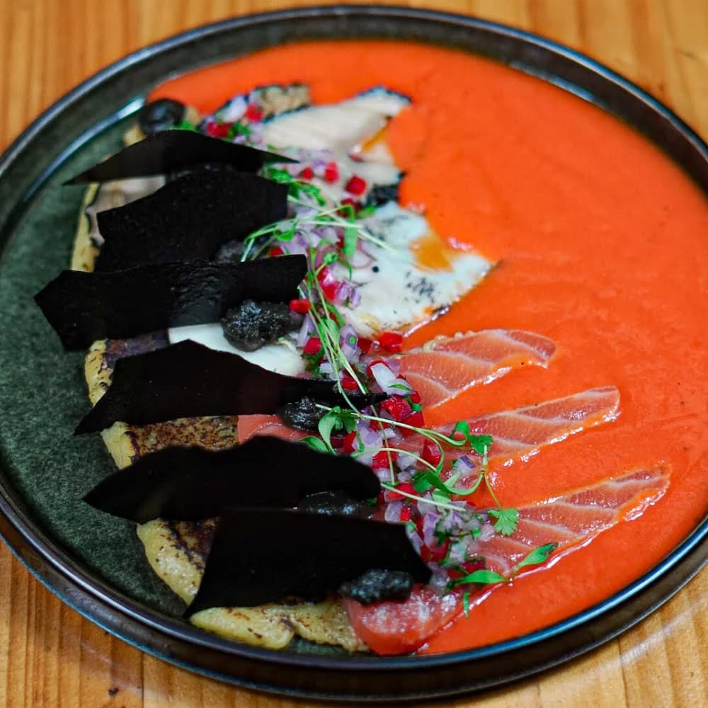 TIRADITO CON LOCOS, LAPAS, SALMON, SALSA DE ROCOTO CITRICO, EMULSIÓN PLATANO AHUMADA, CROCANTE DE SEPIA, POLVO DE ALGA.