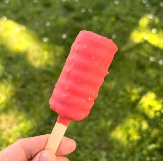 Paleta helada de piure con frutilla y sésamo dorado